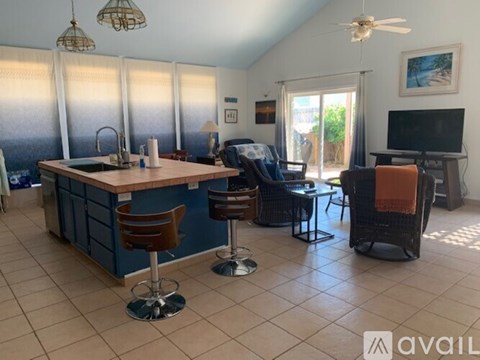 A kitchen with blue cabinets and a bar area with stools.