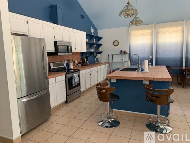 A kitchen with blue walls and white cabinets.