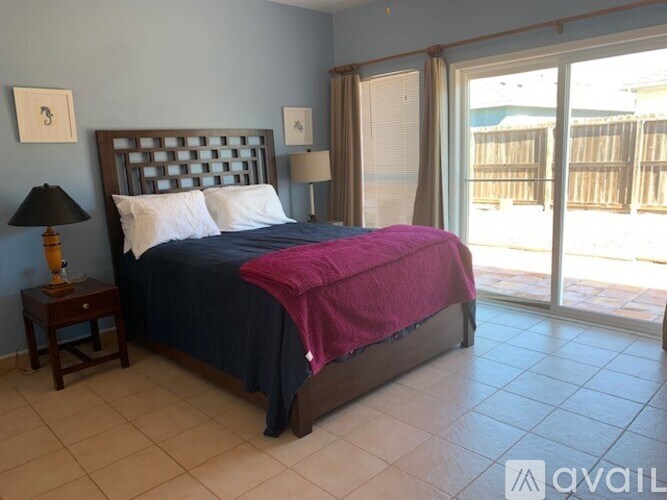 A bedroom with a bed, nightstand, and lamp.