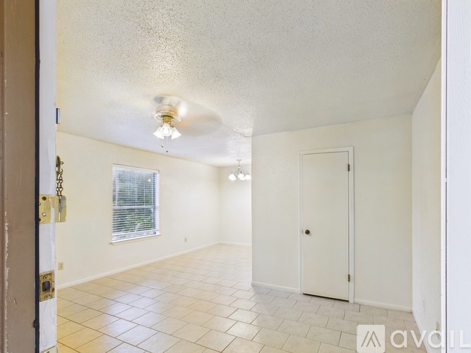 A room with a tiled floor and a window with blinds.