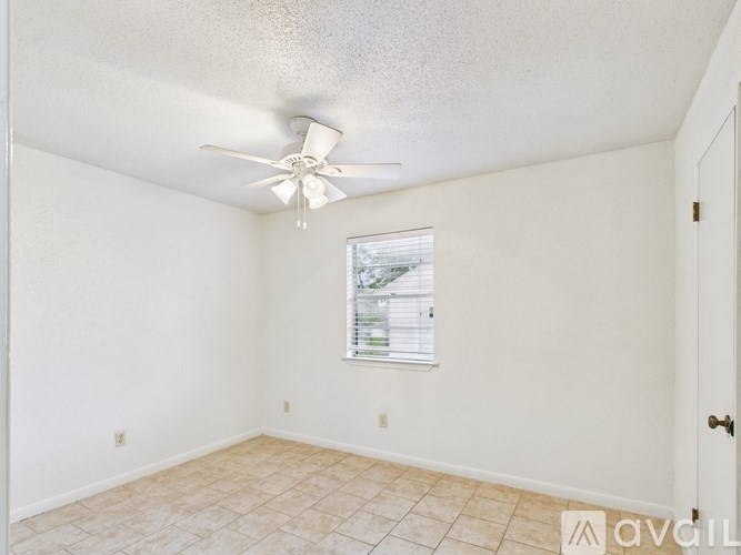 A room with a ceiling fan and a window.
