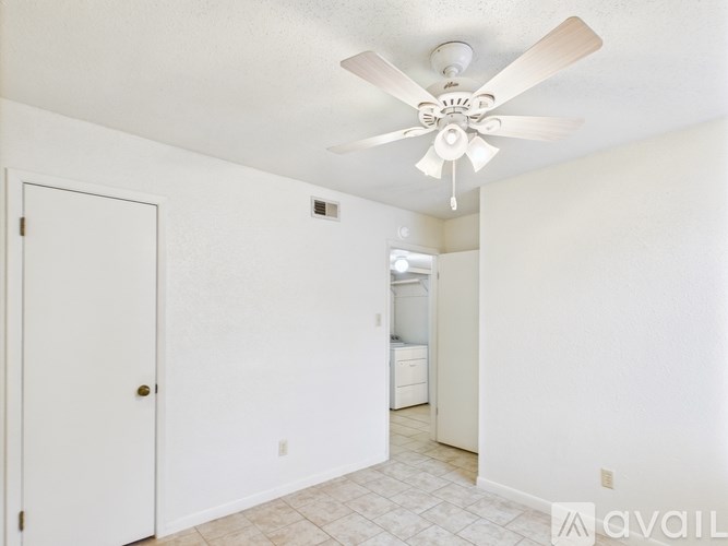 A room with a ceiling fan and a door.