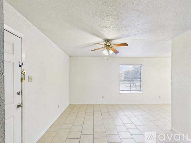 A room with a ceiling fan and a window with a view of a snowy landscape.