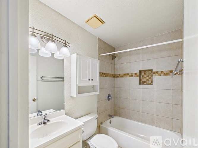 A white bathroom with a sink, toilet, and bathtub.