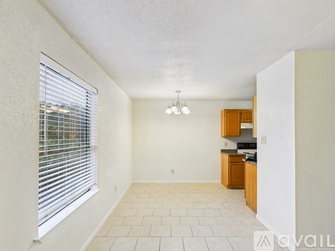 A kitchen area with a window and tiled flooring.