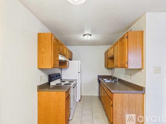 A kitchen with wooden cabinets and a white refrigerator.
