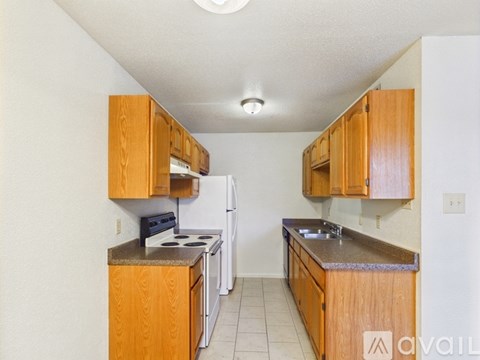 A kitchen with wooden cabinets and a white refrigerator.