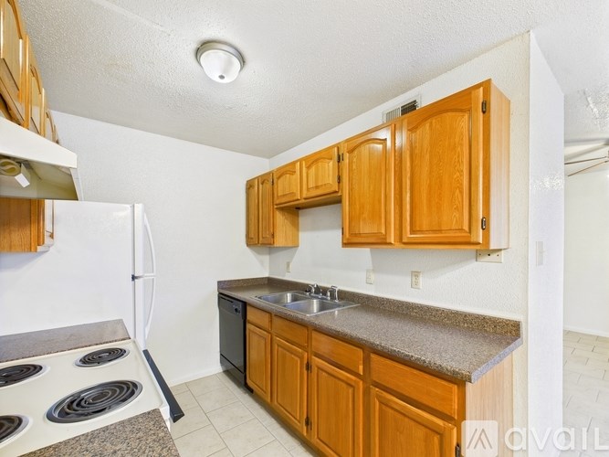 A kitchen with wooden cabinets and a white refrigerator.