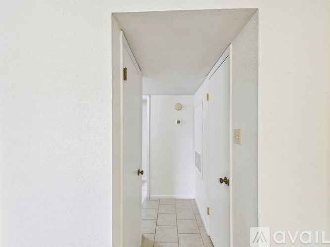 A hallway with a tiled floor and white walls.
