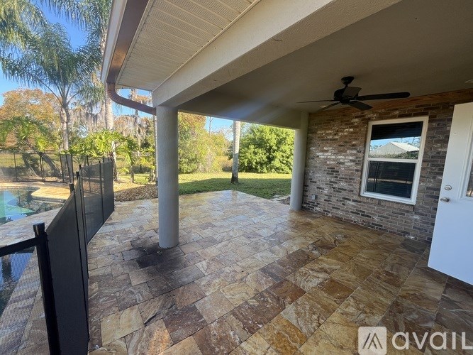 A patio with a tiled floor and a ceiling fan.