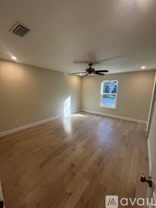 A room with wooden flooring and a ceiling fan.