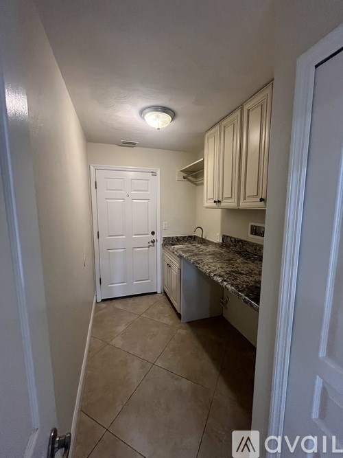 A kitchen with white cabinets and a granite countertop.