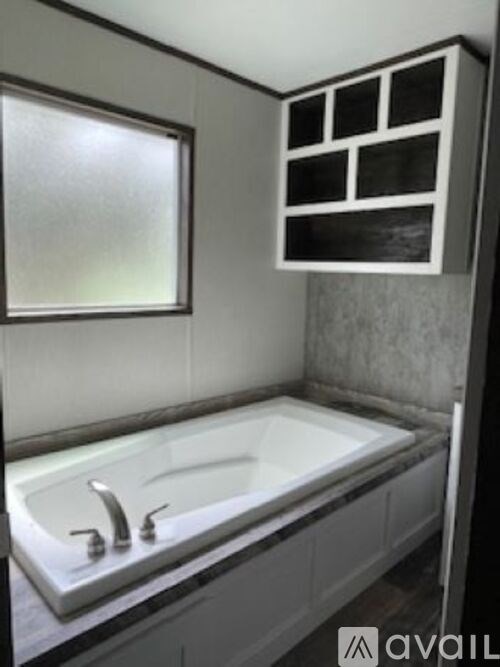 A bathroom with a white sink and a window.