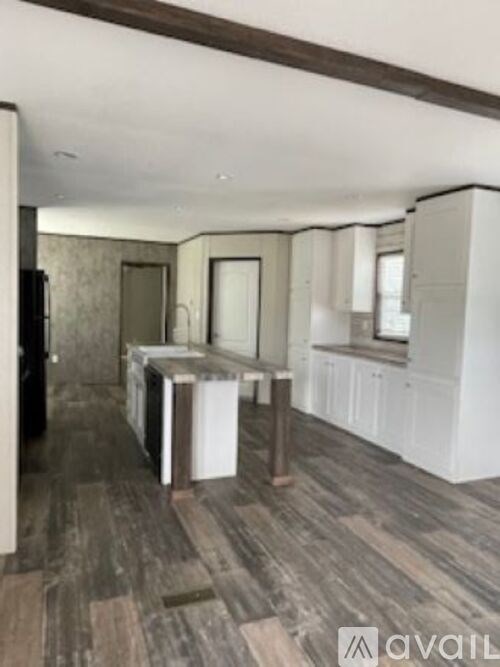 A room with wooden flooring and white walls.