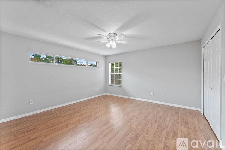 A room with wooden flooring and a ceiling fan.