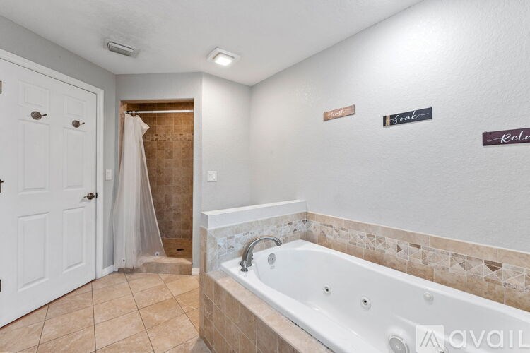 A bathroom with a tub and a door.