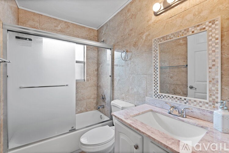 A bathroom with a marble countertop and a walk-in shower.