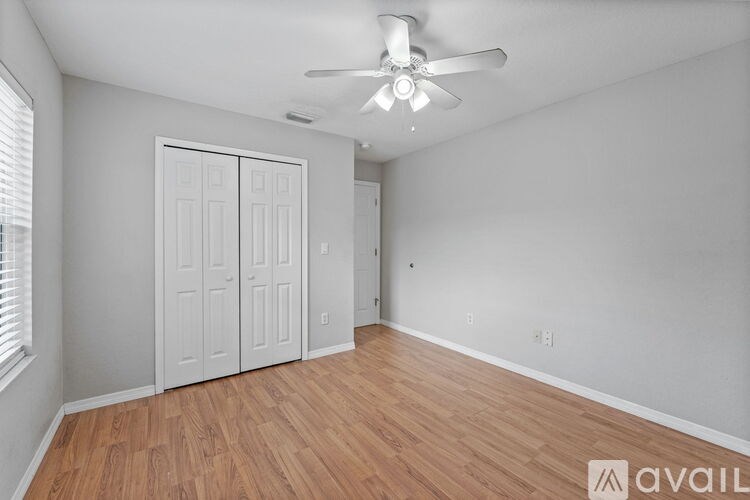 A room with a ceiling fan and two doors.