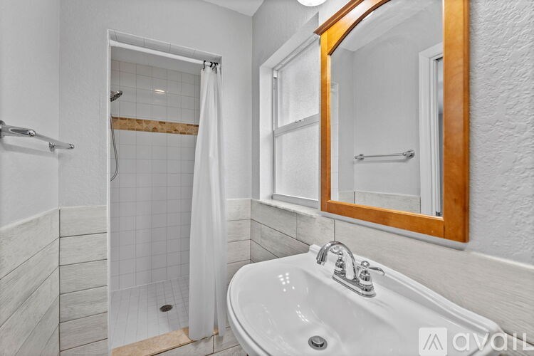 A white bathroom with a white tub and a white shower curtain.