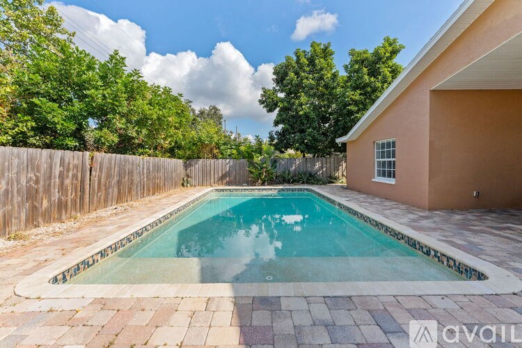 A small pool in a backyard with a wooden fence.
