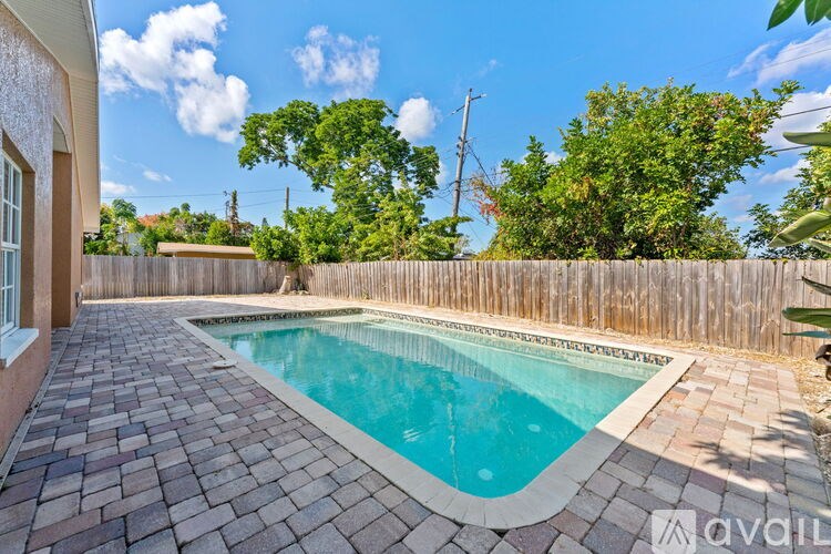 A backyard with a pool and a wooden fence.