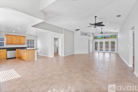 A spacious kitchen with wooden cabinets and a black countertop.
