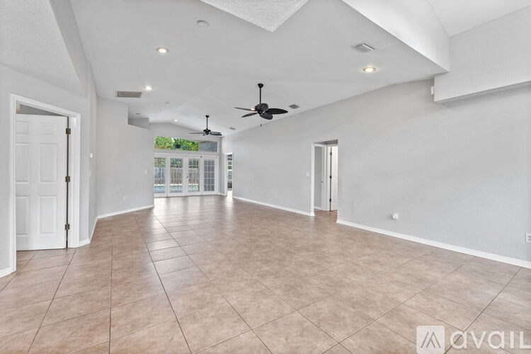 A spacious room with a ceiling fan and tile flooring.