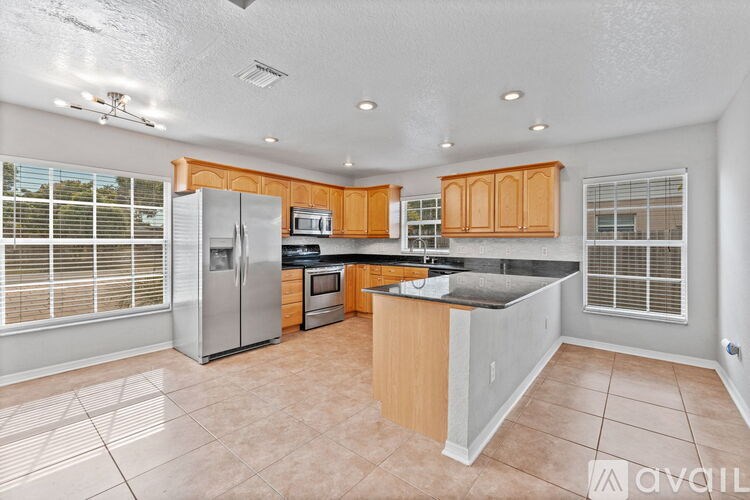 A kitchen with wooden cabinets and a tiled floor.