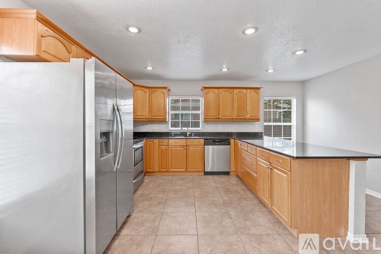 A kitchen with wooden cabinets and a refrigerator.