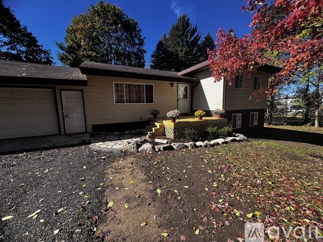 A house with a driveway and trees in the background.