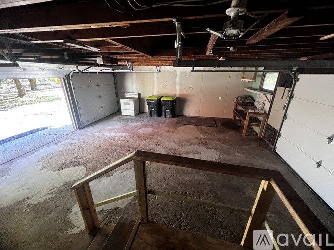 A room with a ceiling fan and a door leading to a garage.