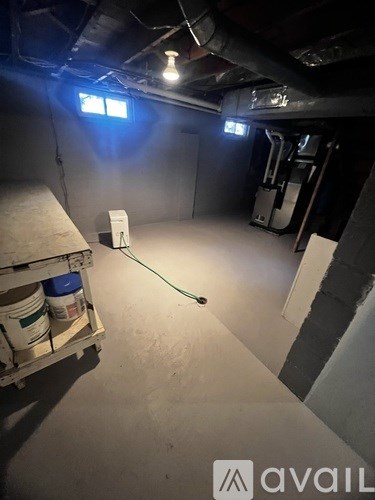 A room with a white bucket and a green hose.