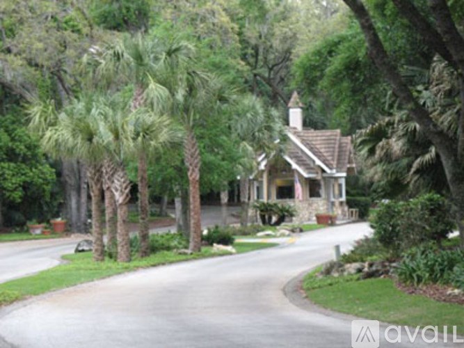 A house with a driveway and trees in front of it.