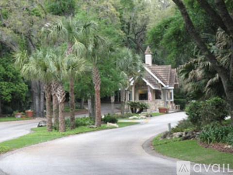A house with a driveway and trees in front of it.