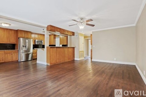 A spacious kitchen with wooden cabinets and a refrigerator.