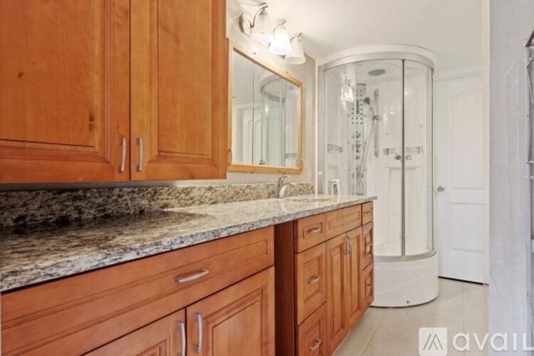A kitchen with wooden cabinets and a marble countertop.