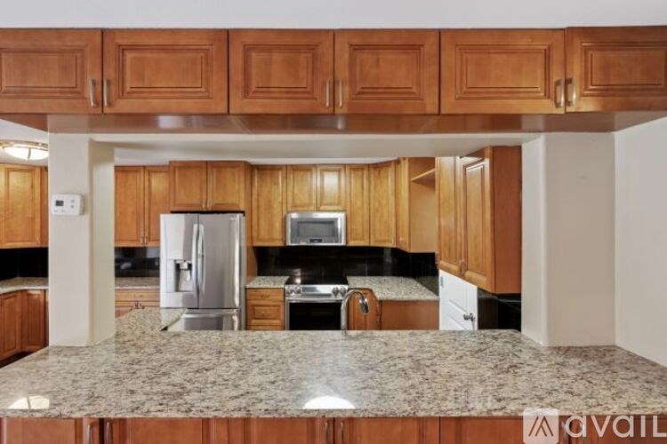 A kitchen with wooden cabinets and granite countertops.
