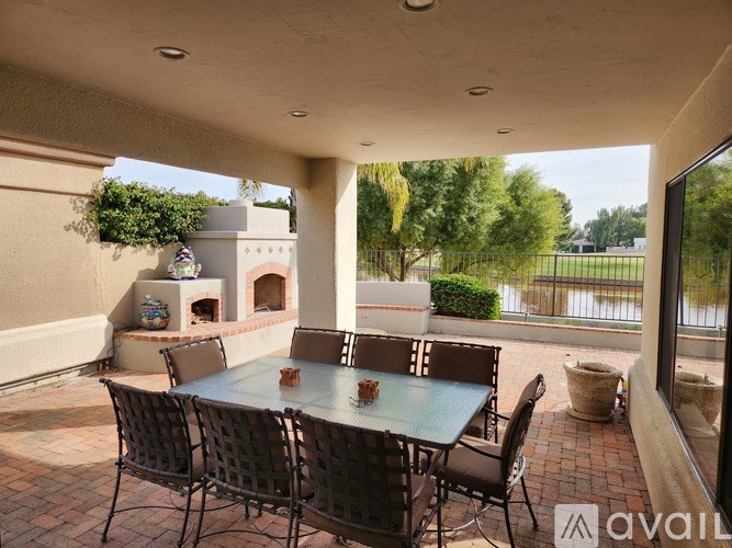 A patio with a table and chairs and a fireplace.