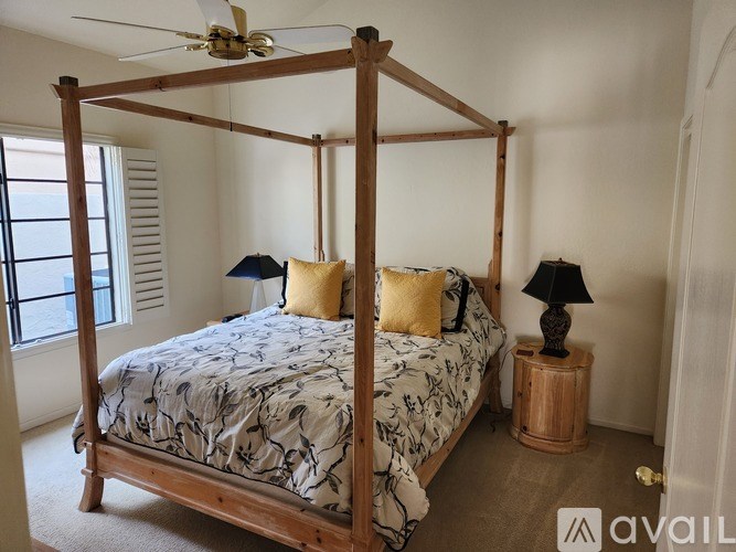 A bedroom with a four-poster bed and a carpeted floor.