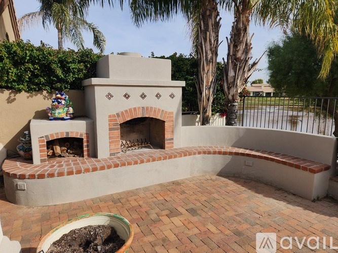 A brick fireplace is in the middle of a patio.
