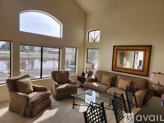 A living room with a couch, chairs, and a coffee table.