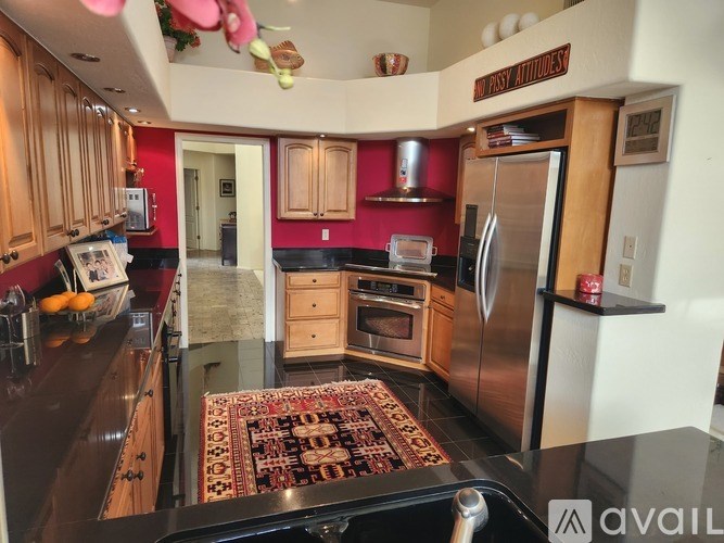 A kitchen with a refrigerator, oven, and sink.
