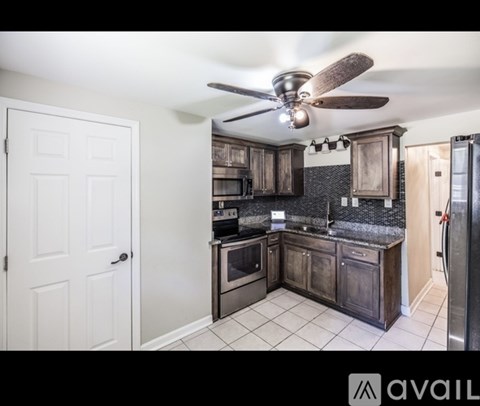 A kitchen with a white door and a ceiling fan.