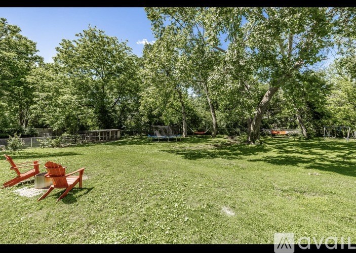 A backyard with a red chair and a picnic table.