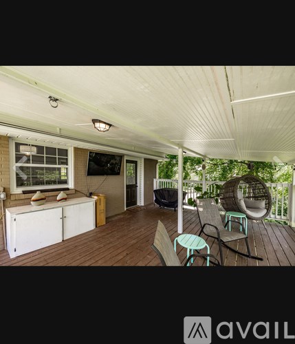 A wooden deck with a white ceiling and a TV mounted on the wall.