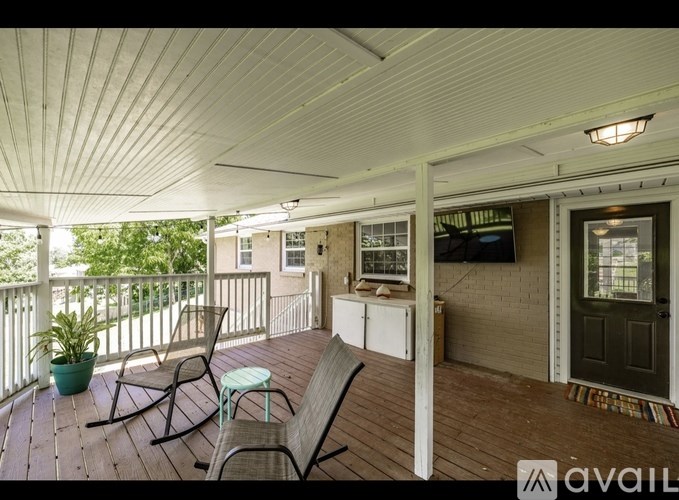 A wooden deck with a bench and a potted plant.