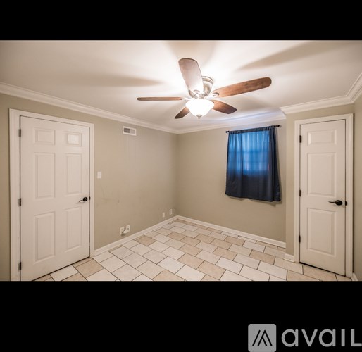 A room with a ceiling fan and tile flooring.