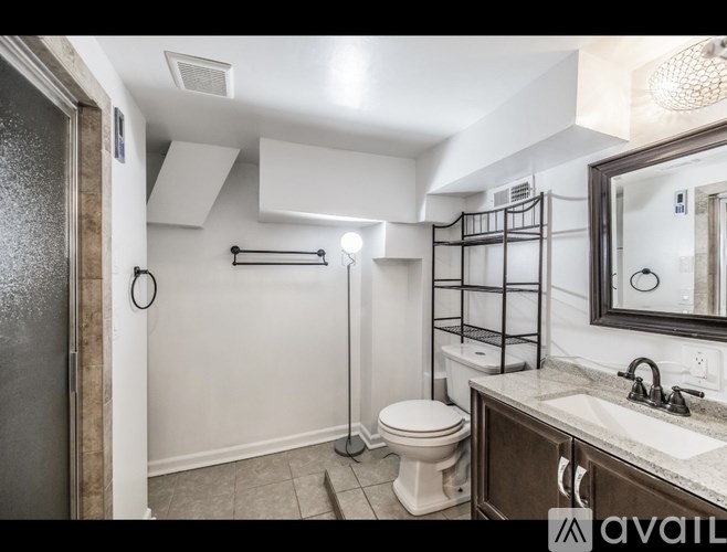 A bathroom with a toilet, sink, and a walk-in shower.