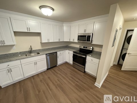 A kitchen with white cabinets and a granite countertop.