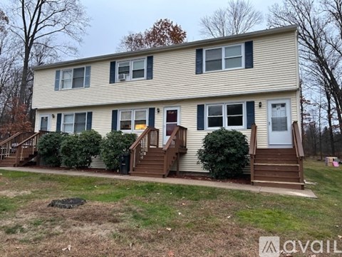 A two-story house with a front porch and a small front yard.